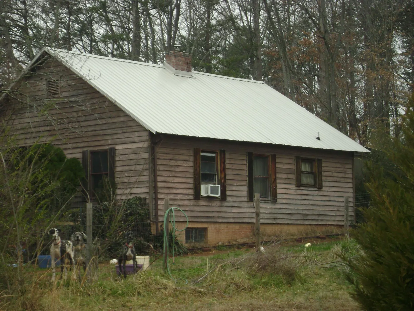 White metal roof on an old wood sided farmhouse, from a Metal Roof Installation job in Jackson